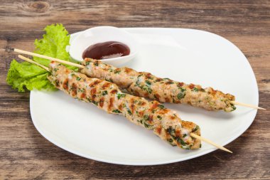 İnce kıymalı domuz şişi kebap ve bbq sosu.