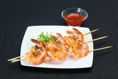 Baharatlı soslu ızgara karides şişi.