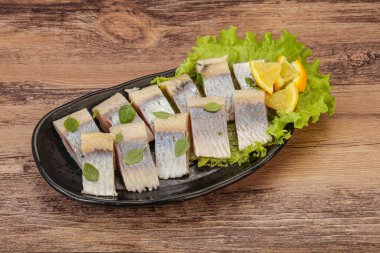 Dilimlenmiş limonla marine edilmiş ringa filetosu.