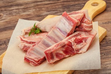 Çiğ kuzu kaburgası pişirmek için biberiye servis edilir.