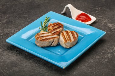 Domates soslu ızgara domuz madalyonu. Biberiye servis ediliyor.