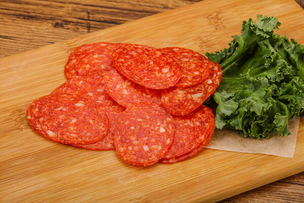 Italian spycy pepperoni sausage slices over board