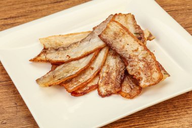 Kızarmış domuz pastırması tabakta.