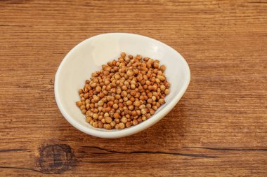 Kuru kişniş tohumları kasede.