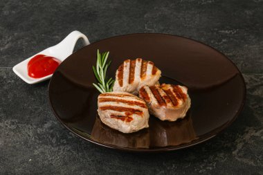 Domates soslu ızgara domuz madalyonu. Biberiye servis ediliyor.