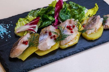 Patates ve soğanlı ringa balığı.