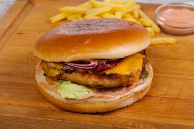 Tavuk, peynir, biber, salatalık ve kırmızı soğanlı hamburger.