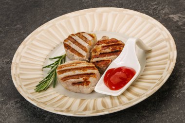 Domates soslu ızgara domuz madalyonu. Biberiye servis ediliyor.