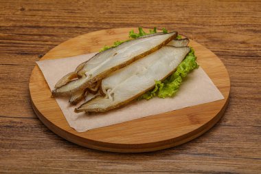 Lezzetli füme halibut balığı aperatifi keser.