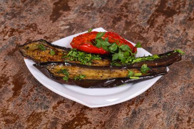 Dolmalık biberli ızgara patlıcan yeşil otlar ve baharatlar servis edilir.