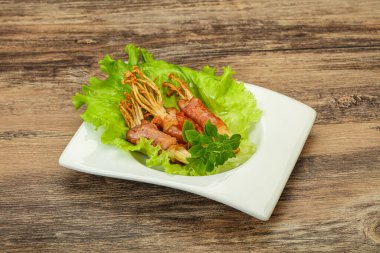 Kızarmış enoki mantarı ve domuz pastırması fesleğen yaprağı.