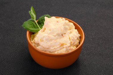 Nane yaprağı servis edilmiş kayısı ile kaymak.