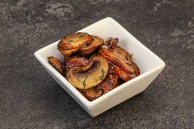 Kavrulmuş şampiyon, kasede otlar ve baharatlar var.