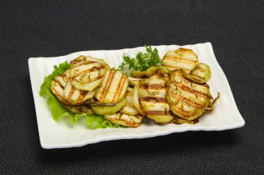 Izgara patlıcan dilimleri fesleğen ve salata yaprakları servis edilir.