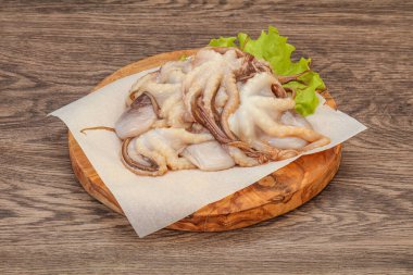 Çiğ deniz ürünleri - ahtapot tahtada pişirmek için.