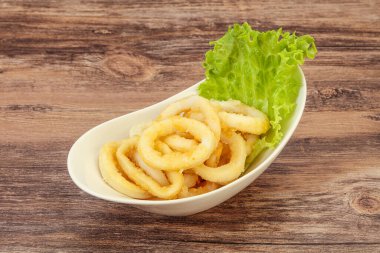 Kavrulmuş kalamar halkaları ve kasede salata.