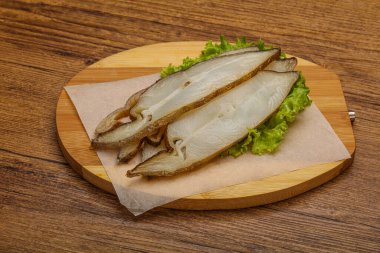 Lezzetli füme halibut balığı aperatifi keser.