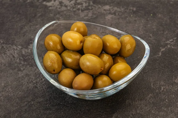 Green pickled olives heap in the bowl