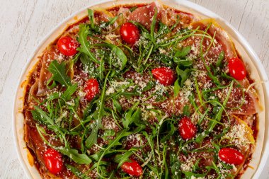 Hamon ve roka ile pizza.