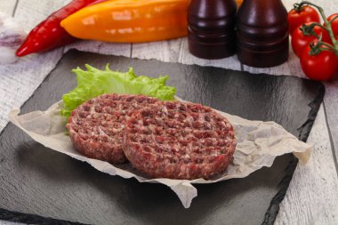 Çiğ burger pirzolası ızgara için hazır.