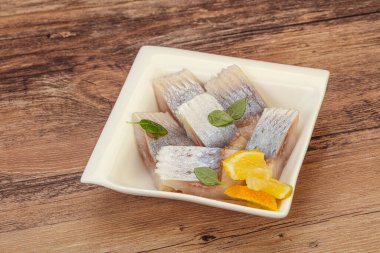 Dilimlenmiş limonla marine edilmiş ringa filetosu.