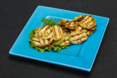 Izgara patlıcan dilimleri fesleğen ve salata yaprakları servis edilir.