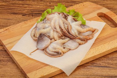 Çiğ deniz ürünleri - ahtapot tahtada pişirmek için.