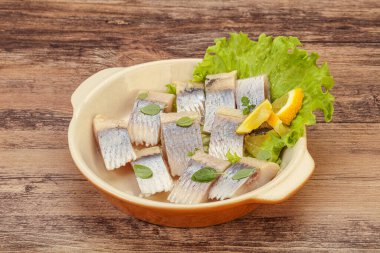 Dilimlenmiş limonla marine edilmiş ringa filetosu.