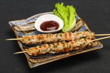 İnce kıymalı domuz şişi kebap ve bbq sosu.