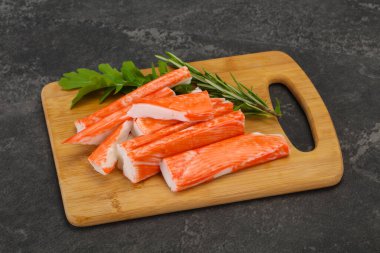 Ahşap tahtanın üzerinde yengeç çubuğu surimi