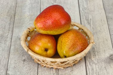 Tahta sepetteki olgun armut yığını.