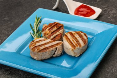 Domates soslu ızgara domuz madalyonu. Biberiye servis ediliyor.