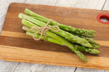 Ahşap tahtanın üzerine çiğ kuşkonmaz yığını