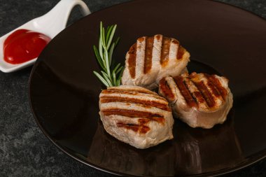 Domates soslu ızgara domuz madalyonu. Biberiye servis ediliyor.