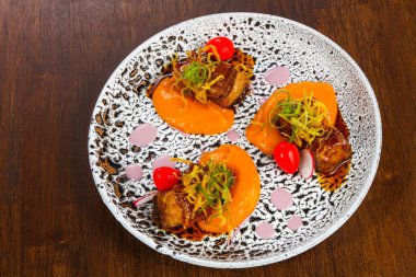 Fırında domuz, havuç sosu ve kızarmış soğan.