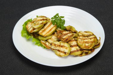 Izgara patlıcan dilimleri fesleğen ve salata yaprakları servis edilir.