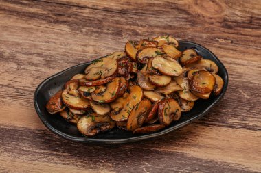 Kavrulmuş şampiyon, kasede otlar ve baharatlar var.