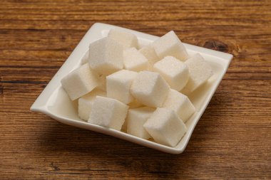 Rafine edilmiş beyaz granüllü şeker yavruları kasede.