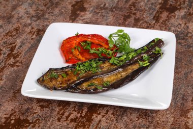 Dolmalık biberli ızgara patlıcan yeşil otlar ve baharatlar servis edilir.