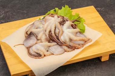 Çiğ deniz ürünleri - ahtapot tahtada pişirmek için.