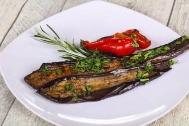 Dolmalık biberli ızgara patlıcan yeşil otlar ve baharatlar servis edilir.