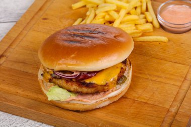 Tavuk, peynir, biber, salatalık ve kırmızı soğanlı hamburger.