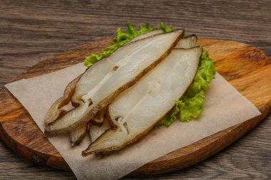 Lezzetli füme halibut balığı aperatifi keser.