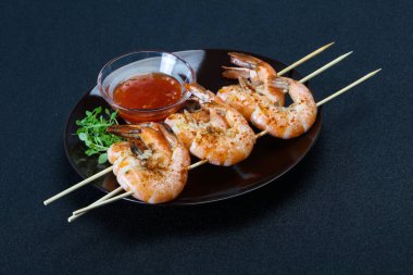 Baharatlı soslu ızgara karides şişi.