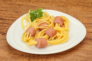 Çocuklar sosisli ve fesleğenli makarna.