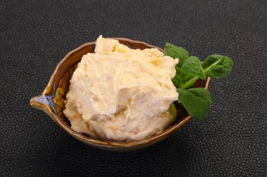 Nane yaprağı servis edilmiş kayısı ile kaymak.