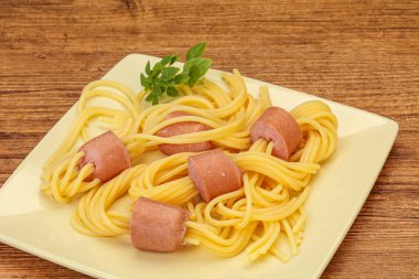 Çocuklar sosisli ve fesleğenli makarna.