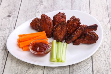 Tavuk kanatları kereviz ve havuç dilimli.