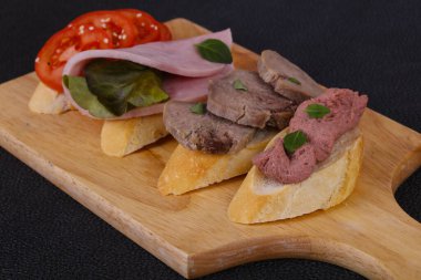 Domatesli, jambonlu ve dilli, salata yapraklı ve kaparili