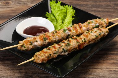 İnce kıymalı domuz şişi kebap ve bbq sosu.